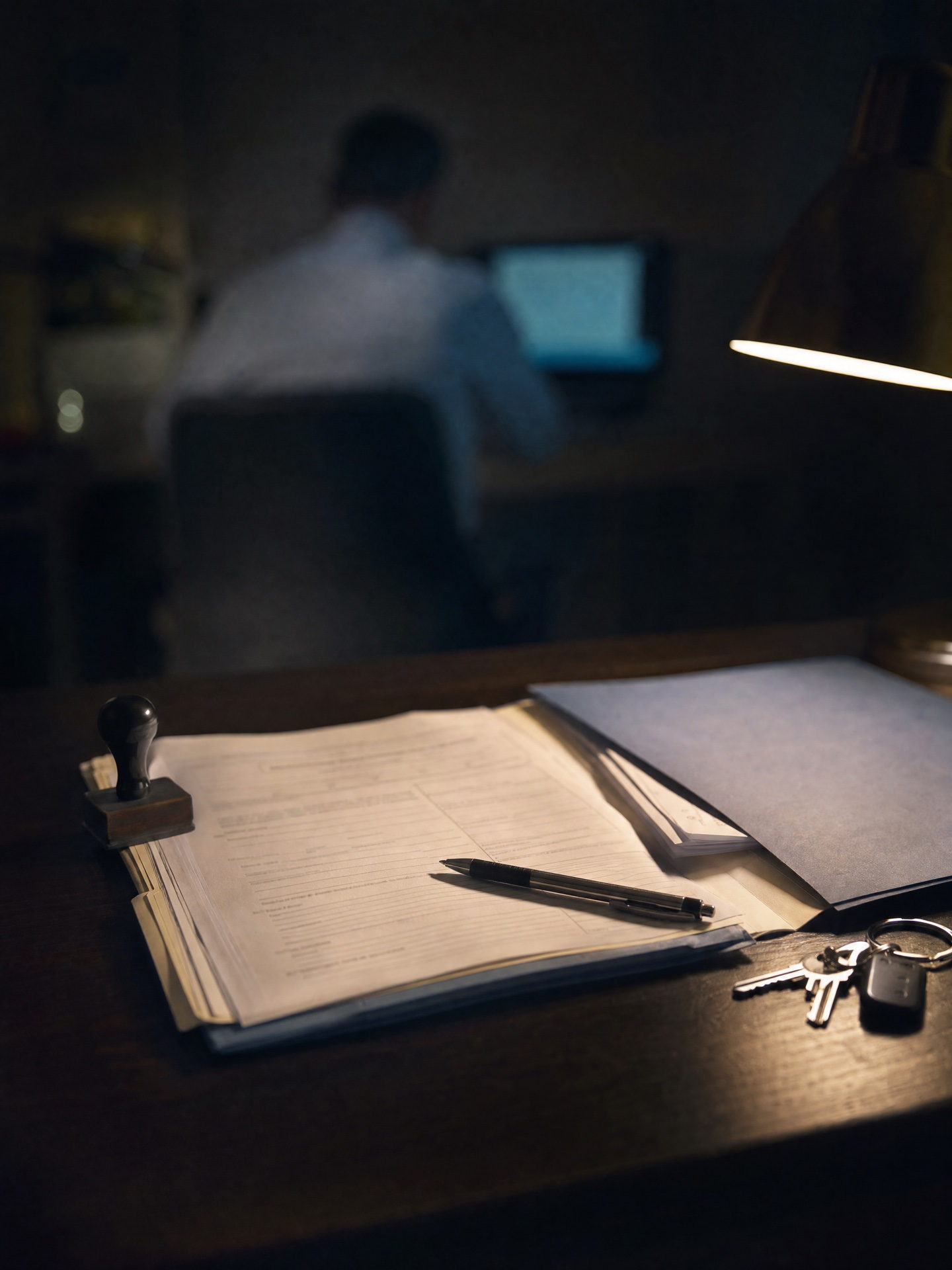 Un dossier administratif ouvert sous la lampe : formulaires, tampon encreur et clés — le cadre légal vérifié avant tout.